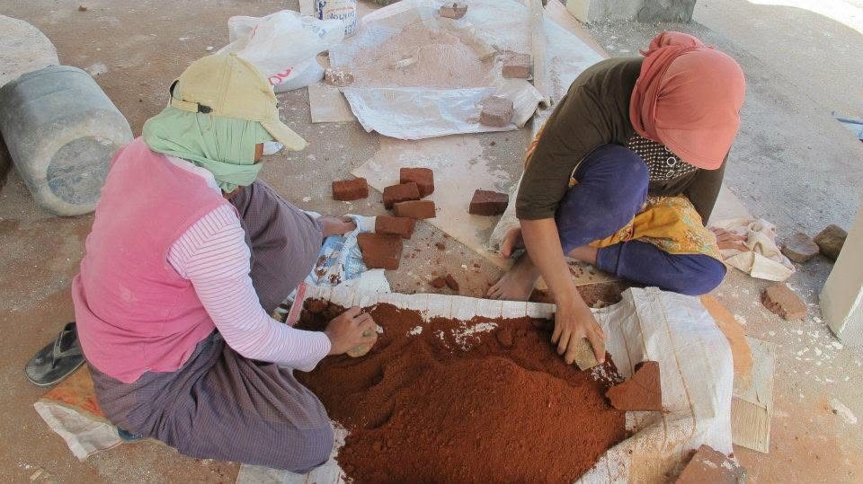 Local artisans hand-sorting clay bricks