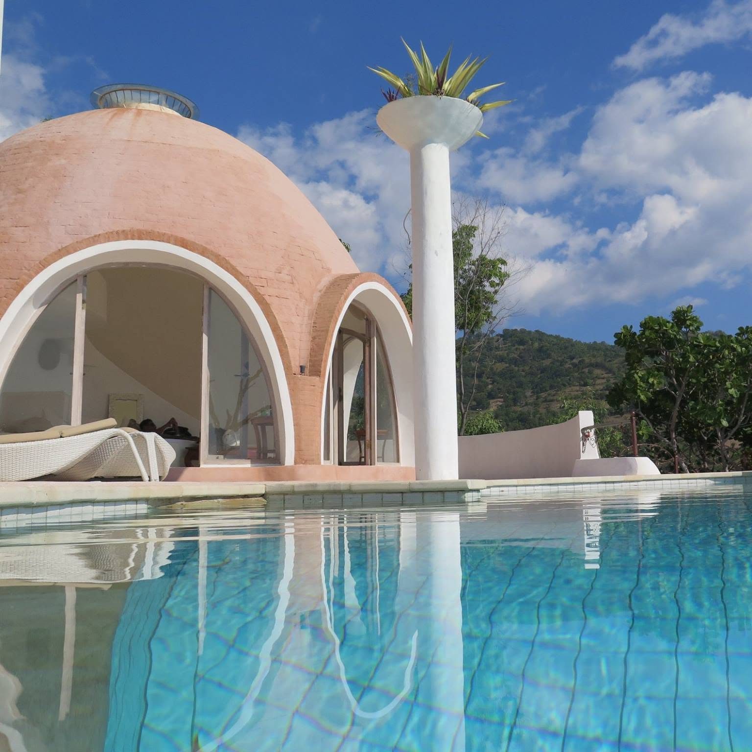 Sculpted columns and pool beside a dome villa